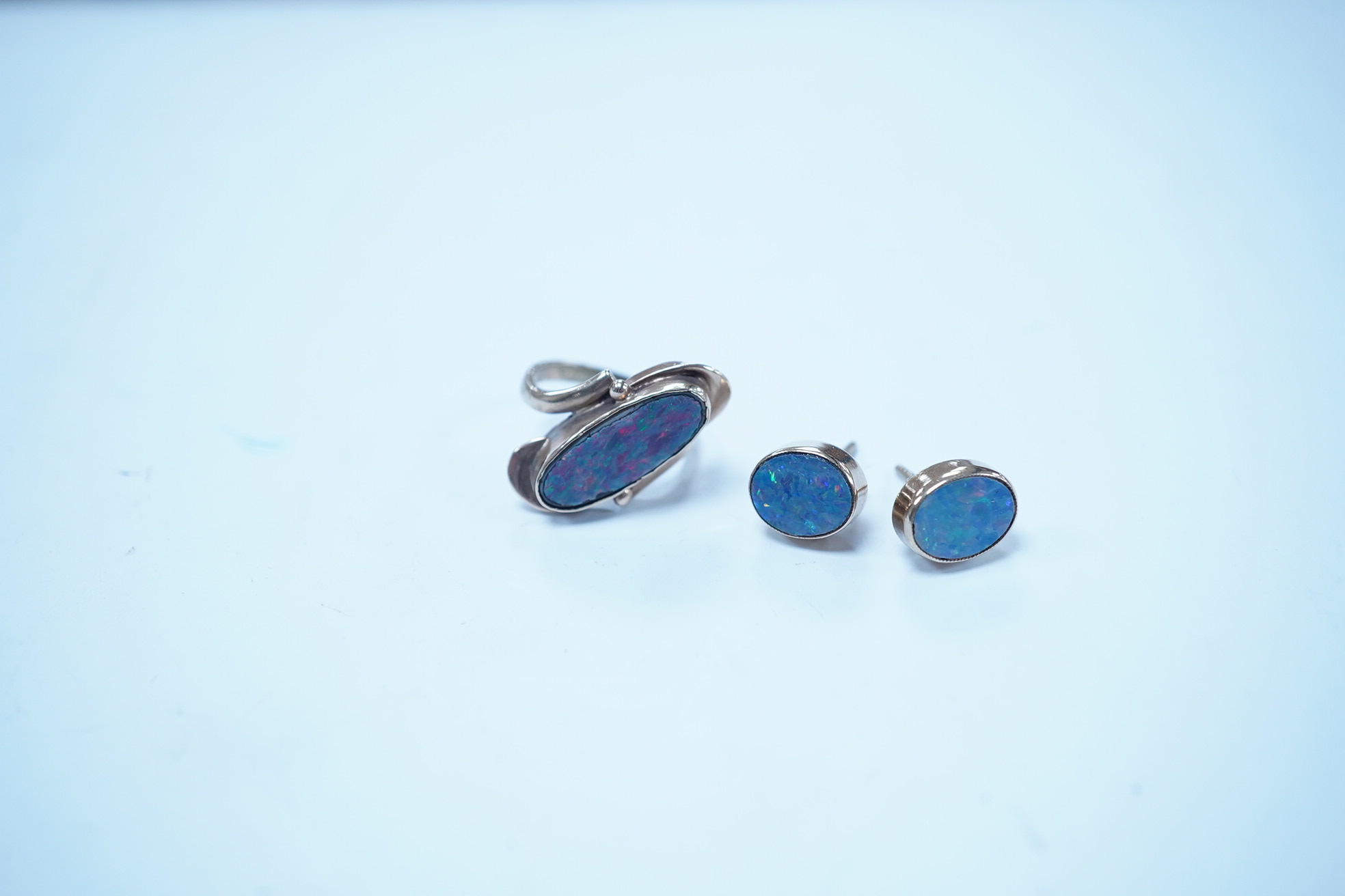 A 9ct and opal doublet ring and a pair of similar earrings, gross weight 4.8 grams. Condition - poor